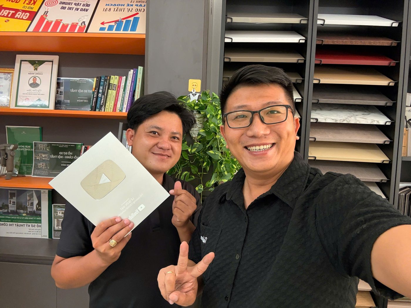 KS. Ngô Đình Khuôn (phải) cùng Lê Quốc Đạt (trái) cầm Nút Bạc YouTube 100.000 người đăng ký tại văn phòng HappyHouse